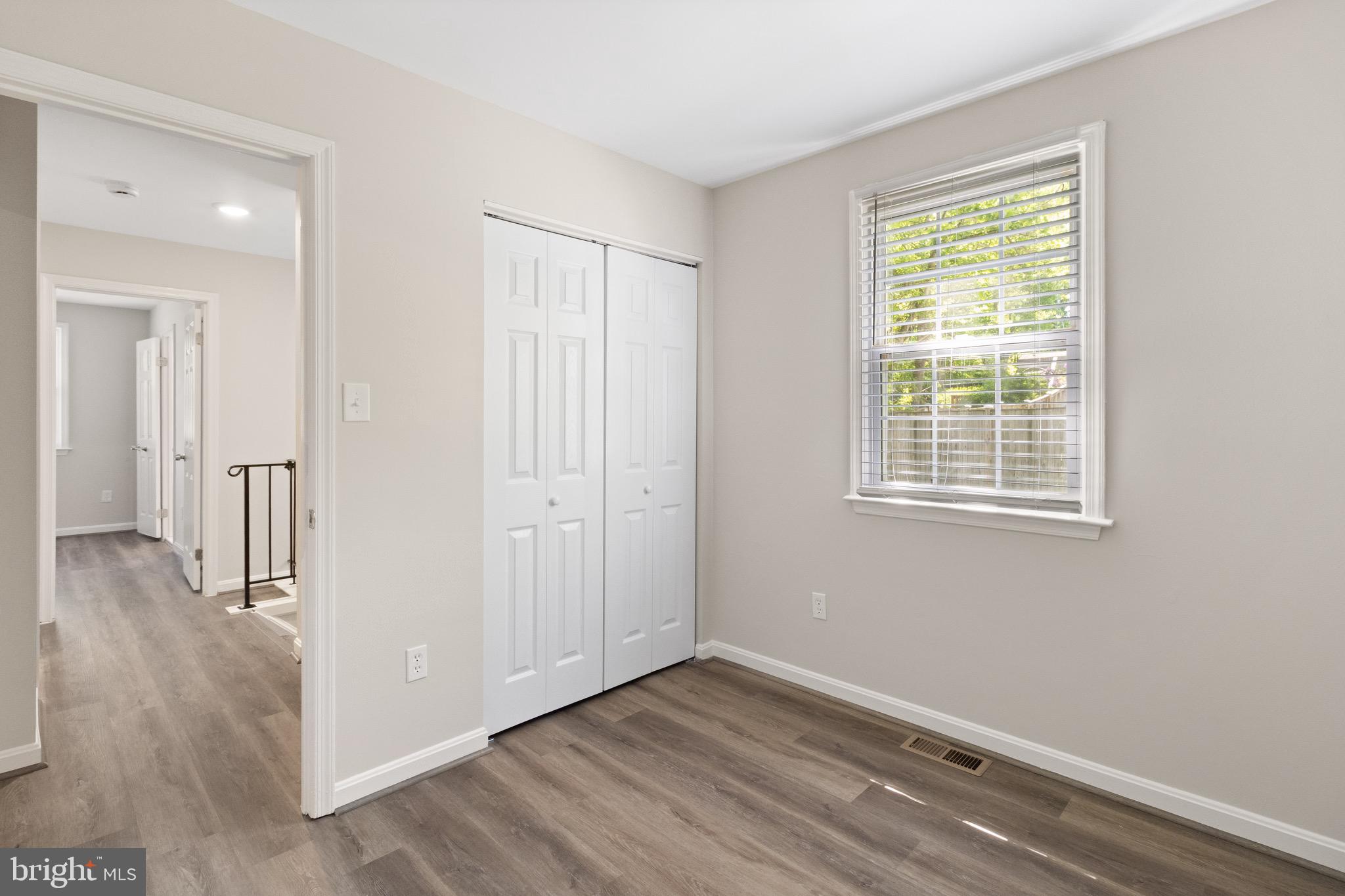 8581 Chester Grove Court Springfield, VA 22153 - Photo 30 of 38 a view of an empty room with wooden floor and a window