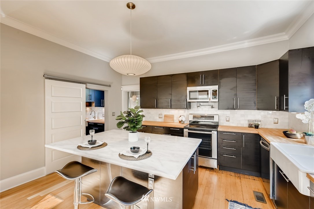 117 24th Avenue Seattle, WA 98122 - Photo 12 of 39 a kitchen with a sink stove and cabinets