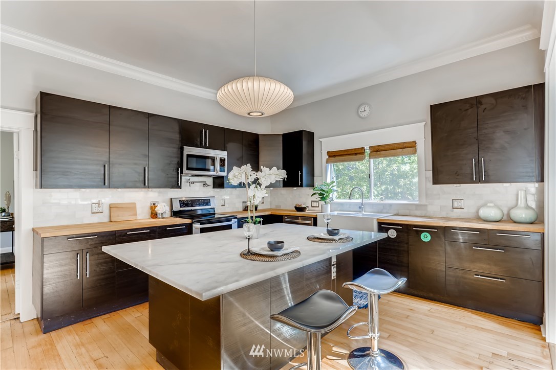 117 24th Avenue Seattle, WA 98122 - Photo 13 of 39 a kitchen with a stove a sink a dining table and chairs