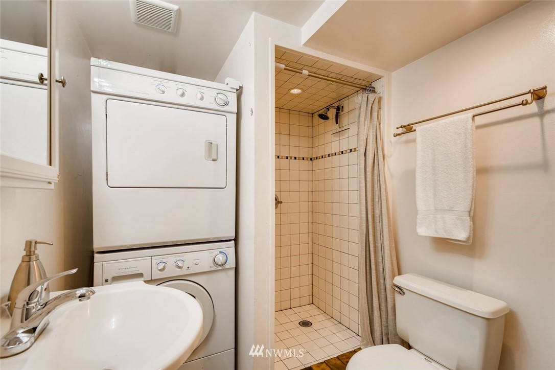117 24th Avenue Seattle, WA 98122 - Photo 33 of 39 a bathroom with a sink a mirror a toilet and shower