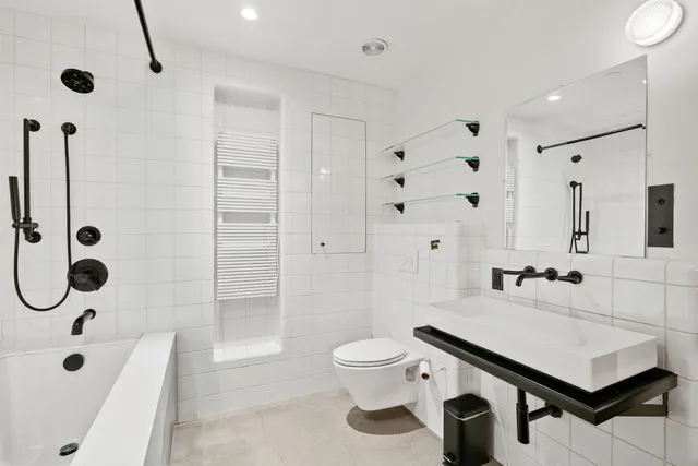 a bathroom with a sink a toilet a mirror and shower