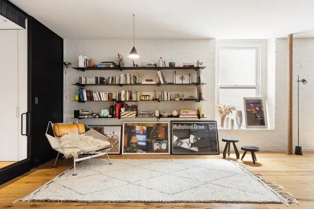 a living room with furniture a rug and a window