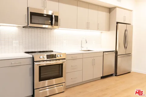 a kitchen with cabinets stainless steel appliances and counter space