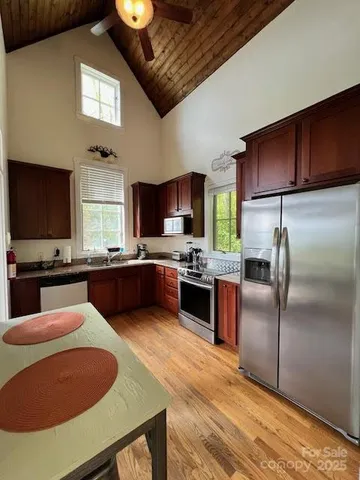 a kitchen with stainless steel appliances granite countertop a sink a stove a microwave a refrigerator and cabinets