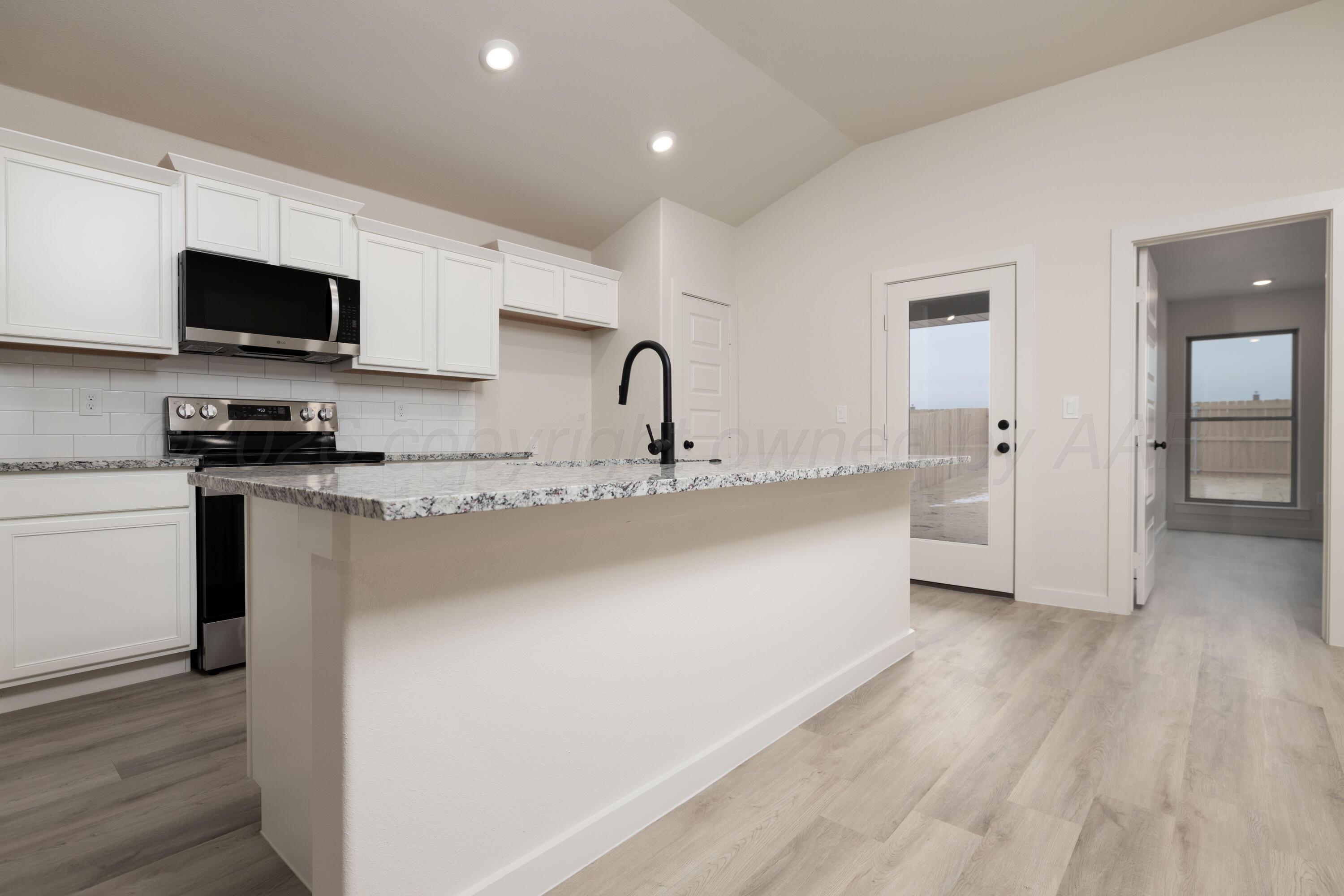 3010 Flycatcher Road Amarillo, TX 79124 - Photo 2 of 11 a kitchen with stainless steel appliances a sink dishwasher a refrigerator and a stove with wooden floor