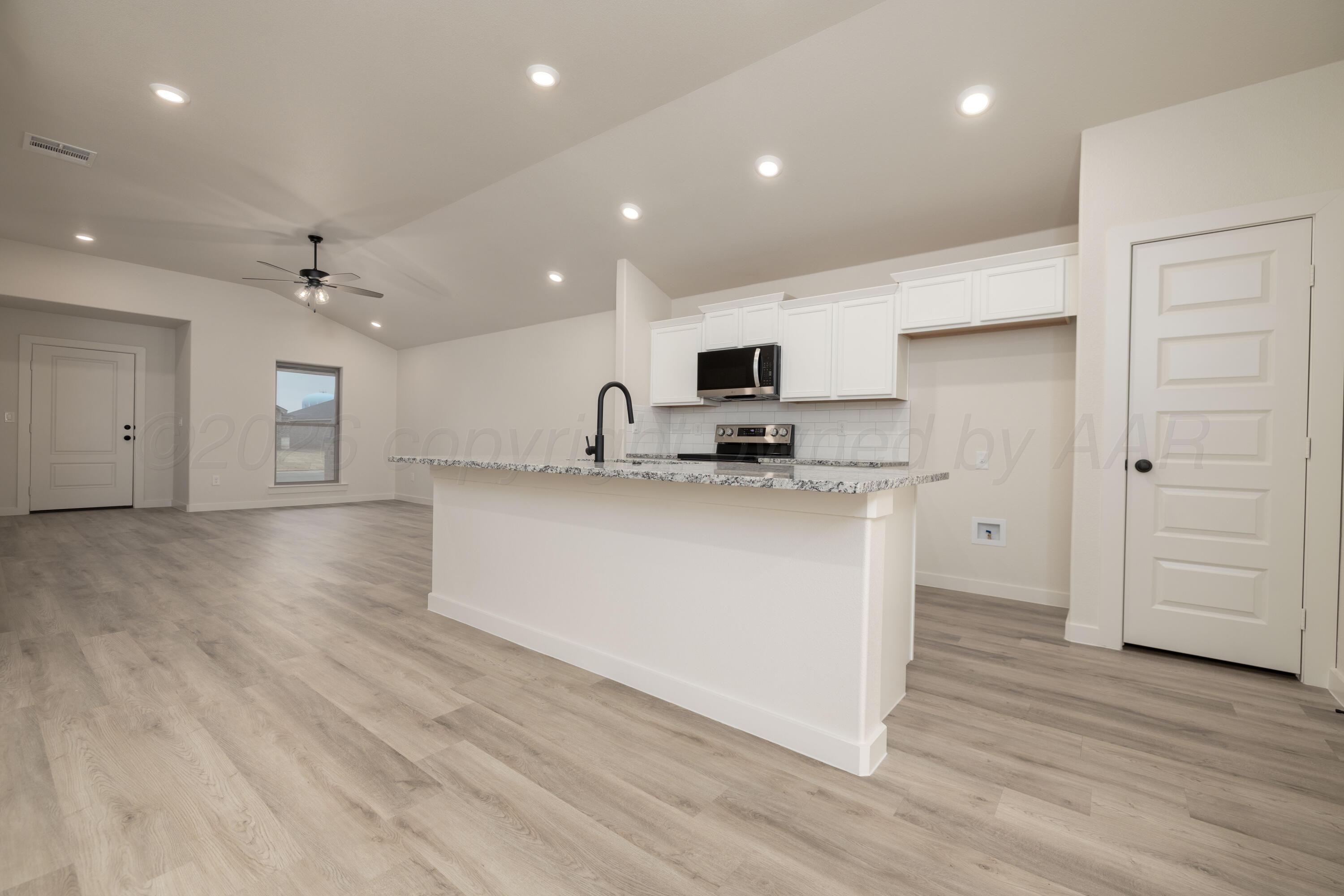 3010 Flycatcher Road Amarillo, TX 79124 - Photo 3 of 11 a kitchen with kitchen island a sink and a stove top oven