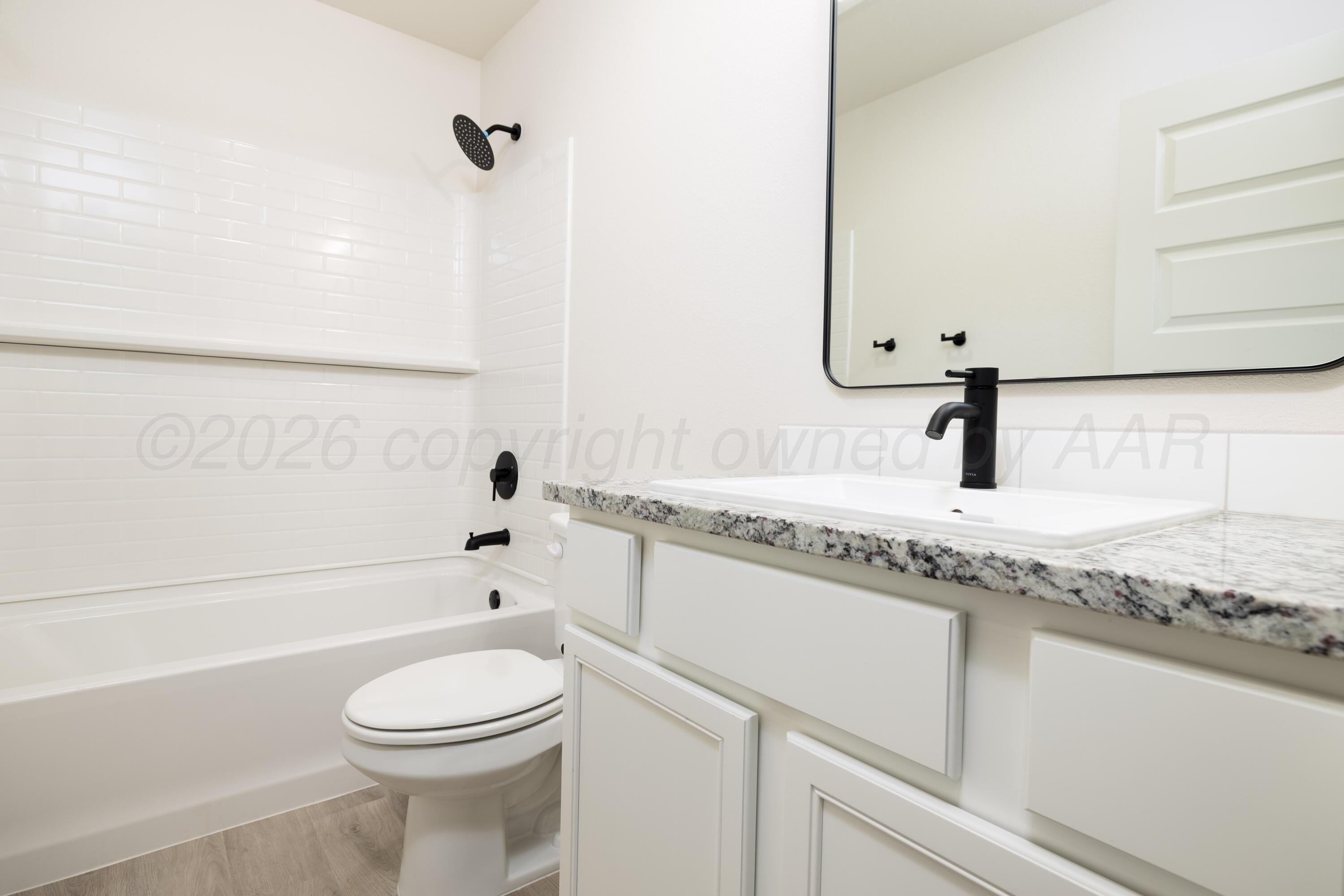 3010 Flycatcher Road Amarillo, TX 79124 - Photo 9 of 11 a bathroom with a granite countertop bathtub sink vanity mirror and toilet