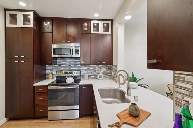 a kitchen with stainless steel appliances a sink stove and refrigerator