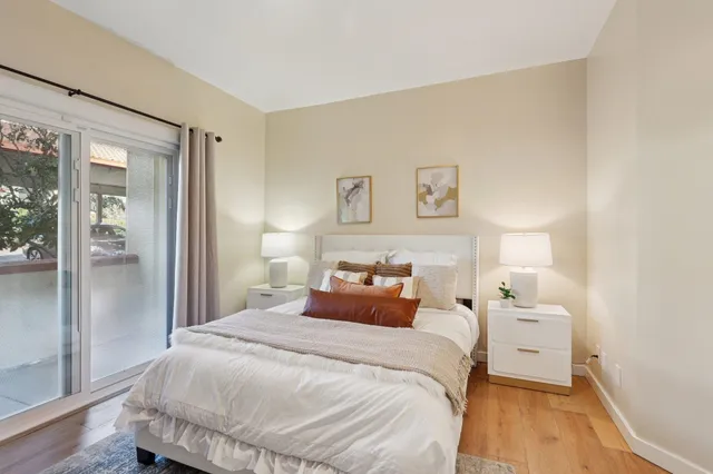 a bedroom with a bed and a large mirror on the dresser