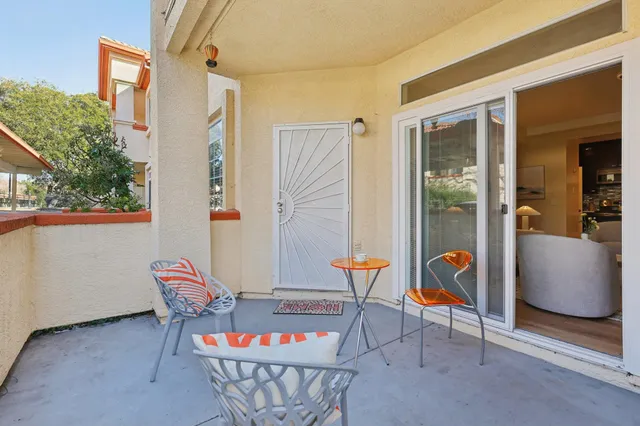 a view of roof deck with table and chairs