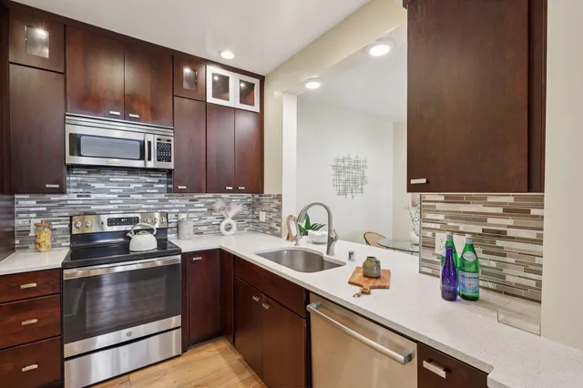 a kitchen with stainless steel appliances granite countertop a sink and a stove
