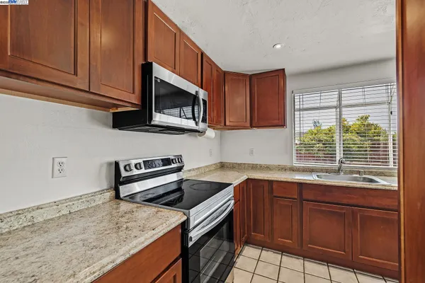 a kitchen with stainless steel appliances granite countertop a sink stove and microwave