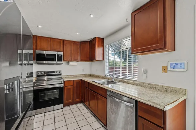 a kitchen with stainless steel appliances granite countertop a refrigerator stove and sink