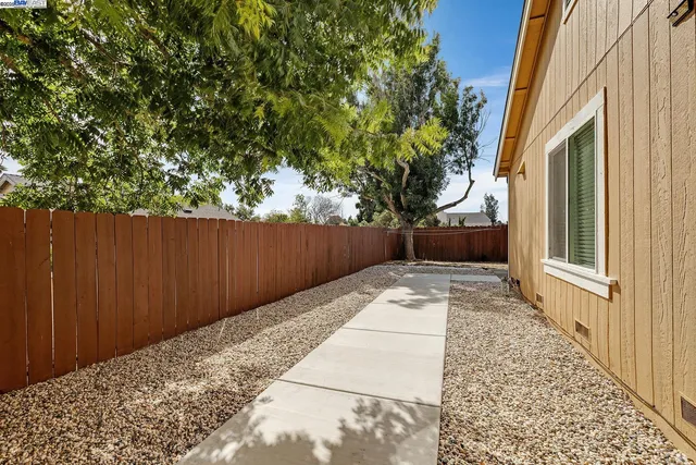 a view of a patio with table and chairs with wooden fence and plants