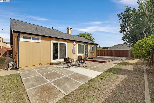 a view of house with backyard and sitting area