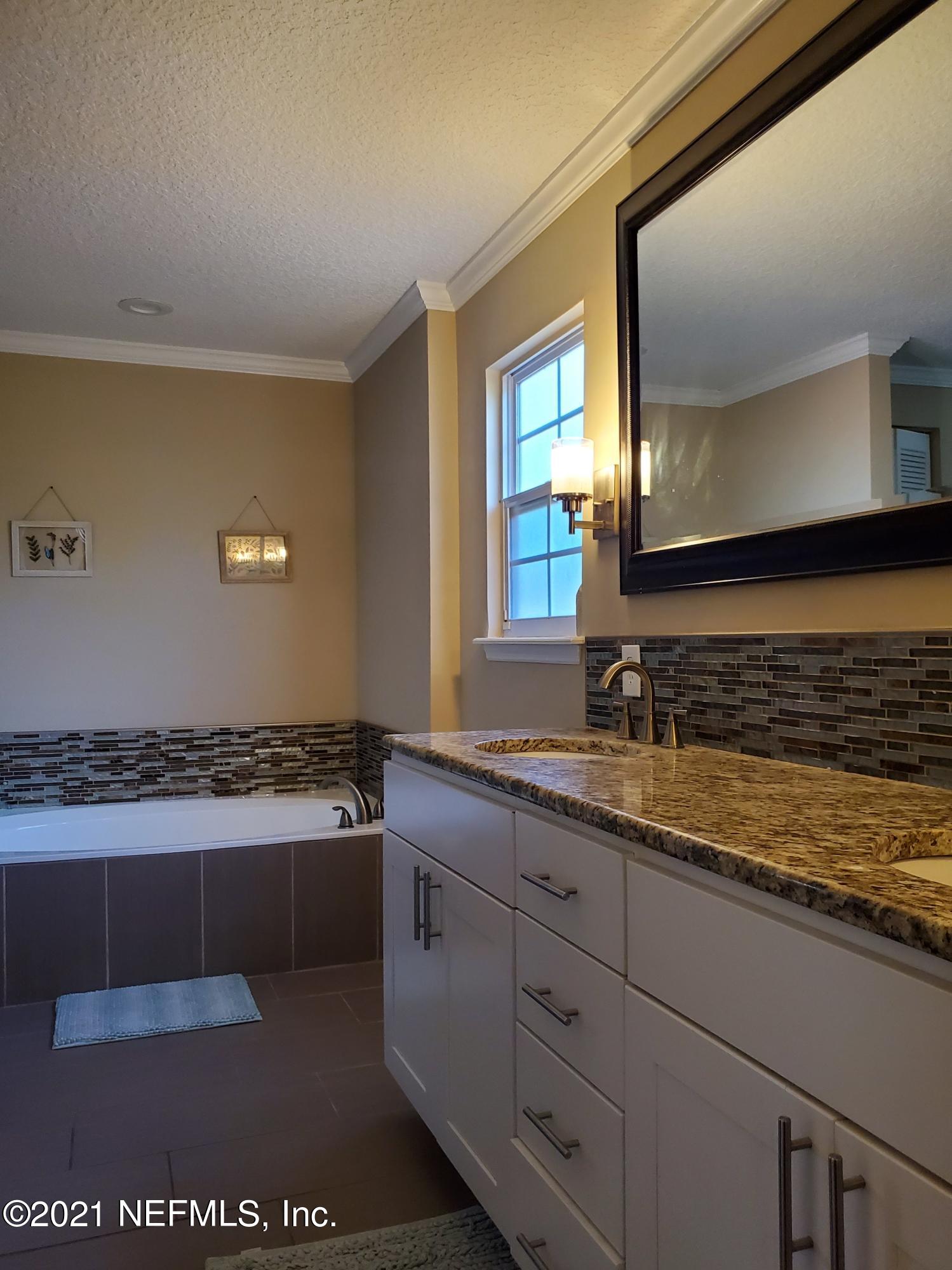 3047 Nautilus Road Middleburg, FL 32068 - Photo 17 of 37 a bathroom with a sink a mirror and a bathtub