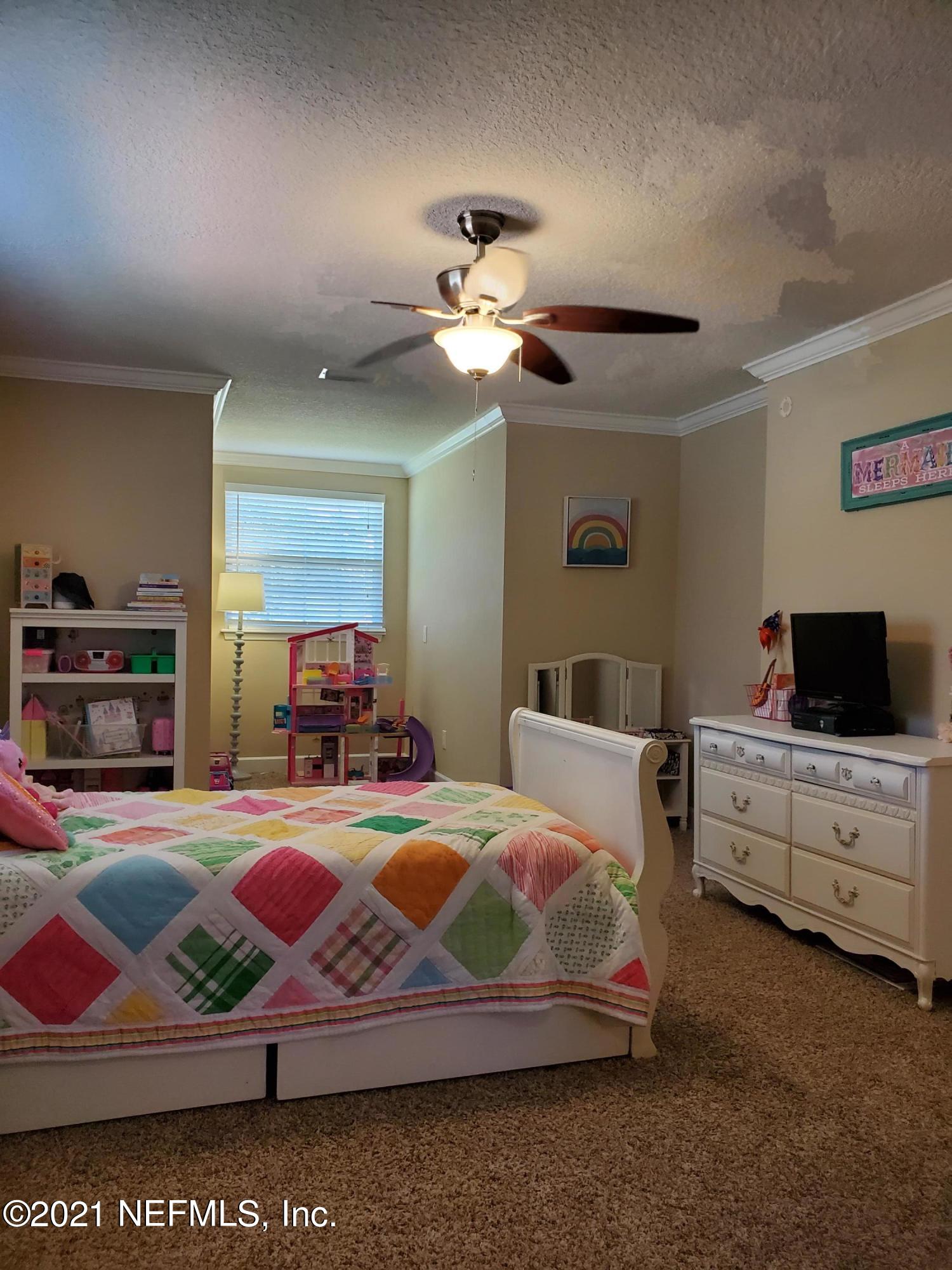 3047 Nautilus Road Middleburg, FL 32068 - Photo 23 of 37 a bedroom with a bed and a chandelier