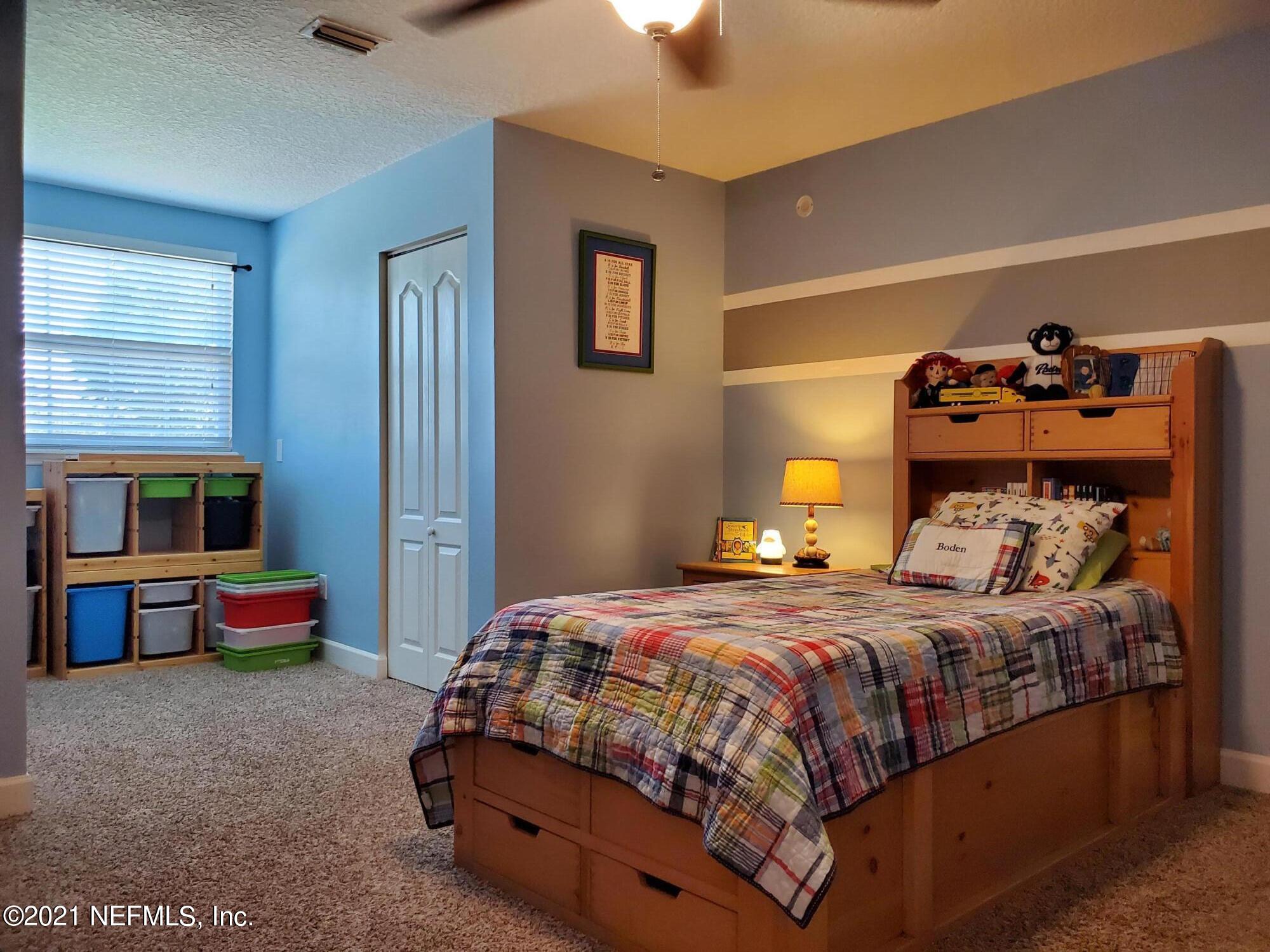 3047 Nautilus Road Middleburg, FL 32068 - Photo 26 of 37 a bedroom with a bed and a chandelier