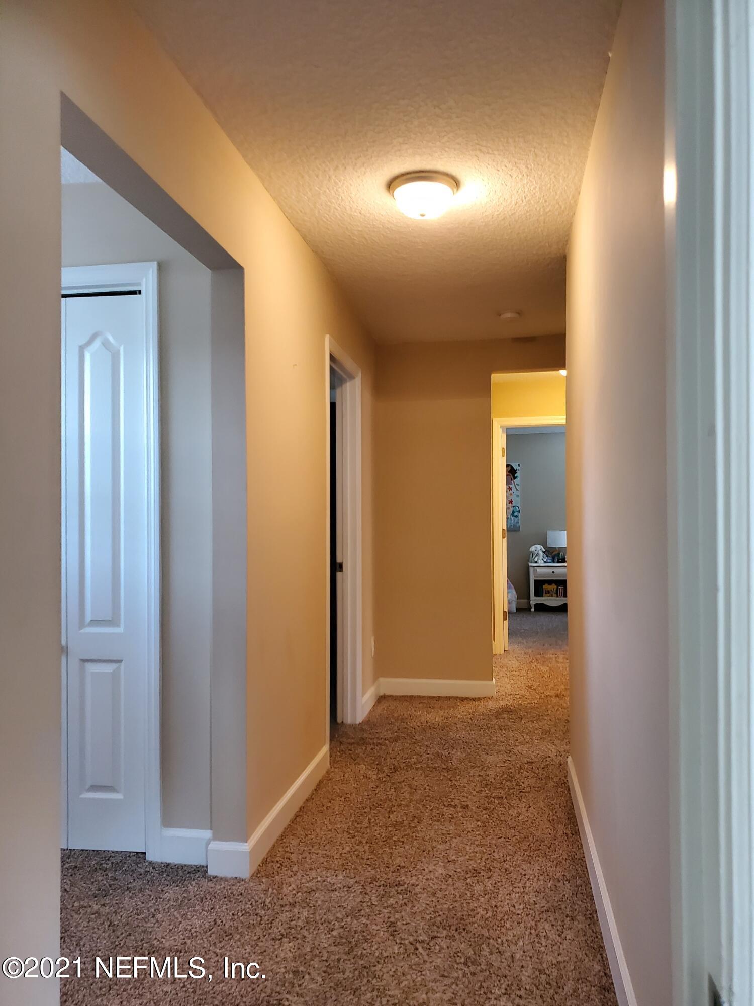 3047 Nautilus Road Middleburg, FL 32068 - Photo 30 of 37 a view of a hallway with wooden shelves