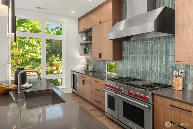 a kitchen with stainless steel appliances granite countertop a stove a sink and a microwave