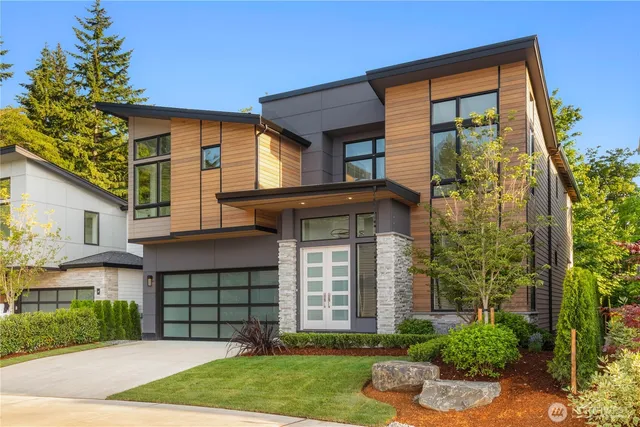 a front view of a house with a yard and potted plants