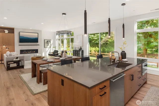 a kitchen with counter top space a sink and living room view