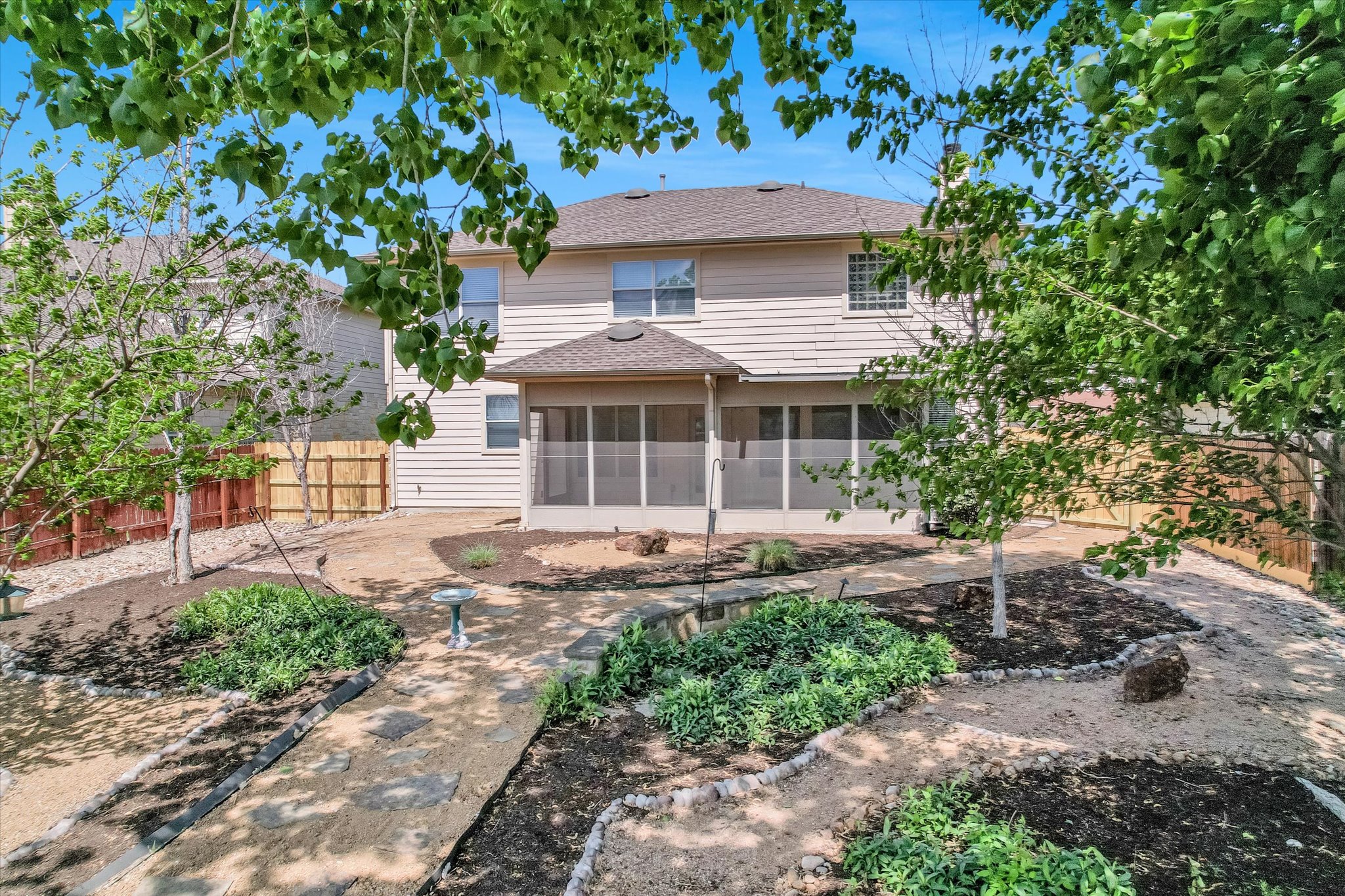 4029 Lake Edge Way Pflugerville, TX 78660 - Photo 26 of 35 Rear view of house featuring a fenced backyard, a sunroom, and roof with shingles