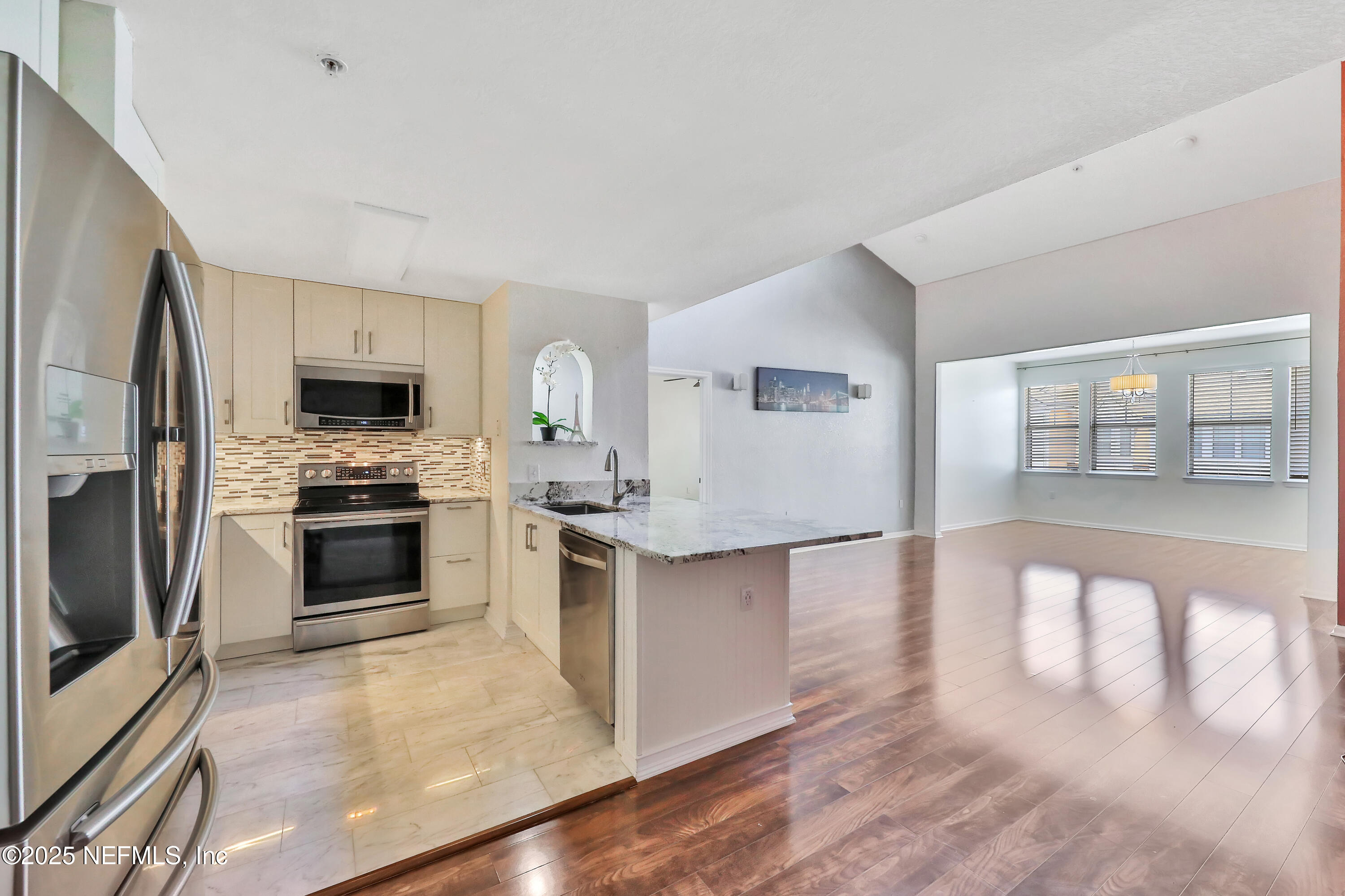 a kitchen with granite countertop a stove top oven and refrigerator