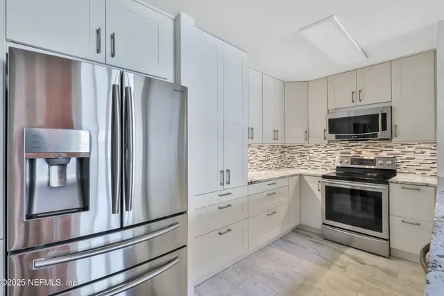a kitchen with white cabinets stainless steel appliances and sink