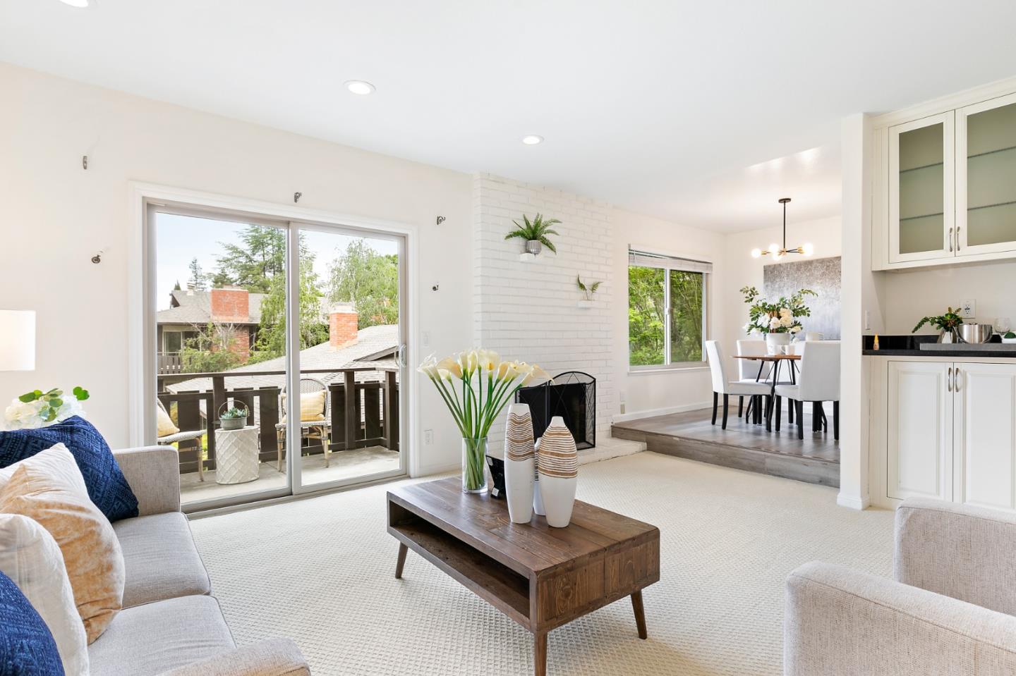 a living room with fireplace furniture and a large window