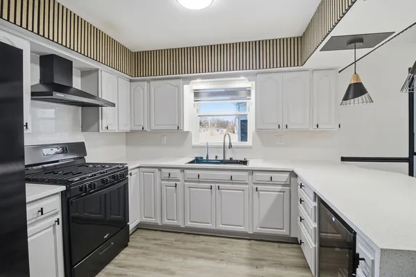 a kitchen with stainless steel appliances granite countertop a sink a stove and cabinets