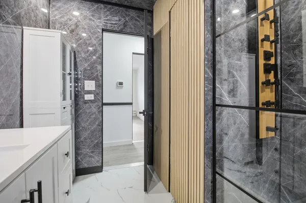 a bathroom with a granite countertop shower a sink and a mirror