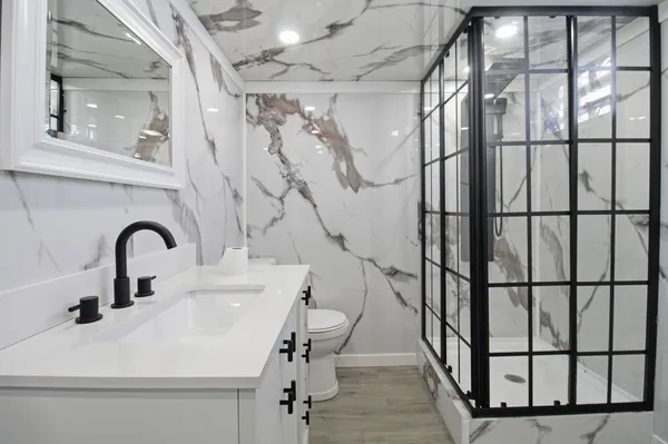 a bathroom with a sink and mirror with bathtub