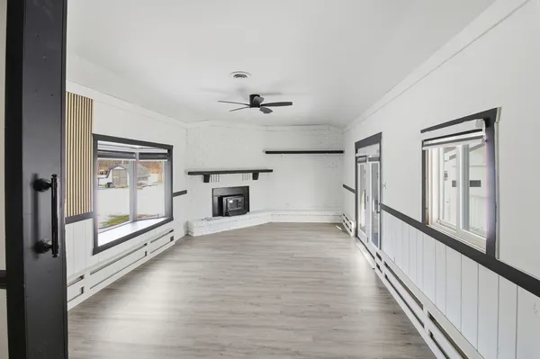 a view of an empty room with a fireplace and a window