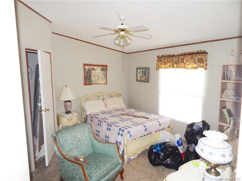 2193 State Rd S-13-106 Pageland, SC 29728 - Photo 13 of 19 a bedroom with a bed and a chandelier