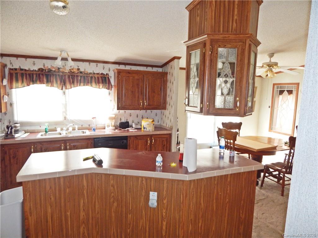 2193 State Rd S-13-106 Pageland, SC 29728 - Photo 7 of 19 a living room with stainless steel appliances granite countertop a couch a dining table and chairs with wooden floor