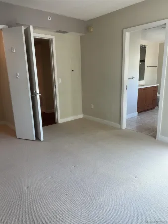 an empty room with closet and mirror