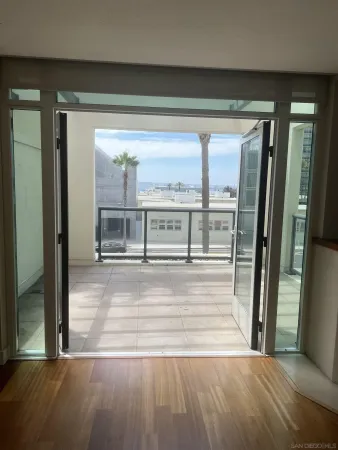 a view of a hallway with wooden floor and dining room