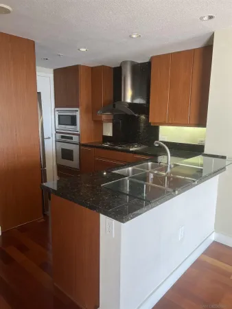 a kitchen with stainless steel appliances granite countertop a sink a stove and a microwave with wooden floor