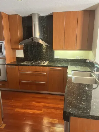 a kitchen with granite countertop a sink and a stove