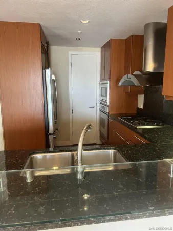 a kitchen with granite countertop a sink and a stove