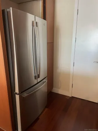 a view of a refrigerator in kitchen and empty racks