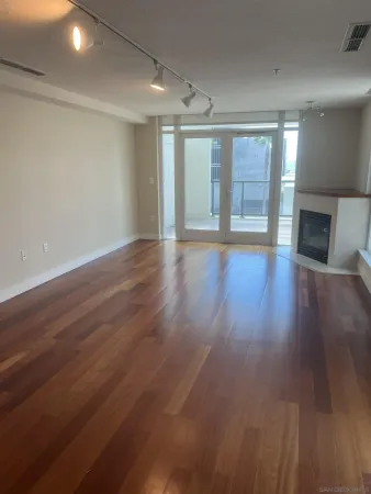 a view of empty room with wooden floor and fireplace