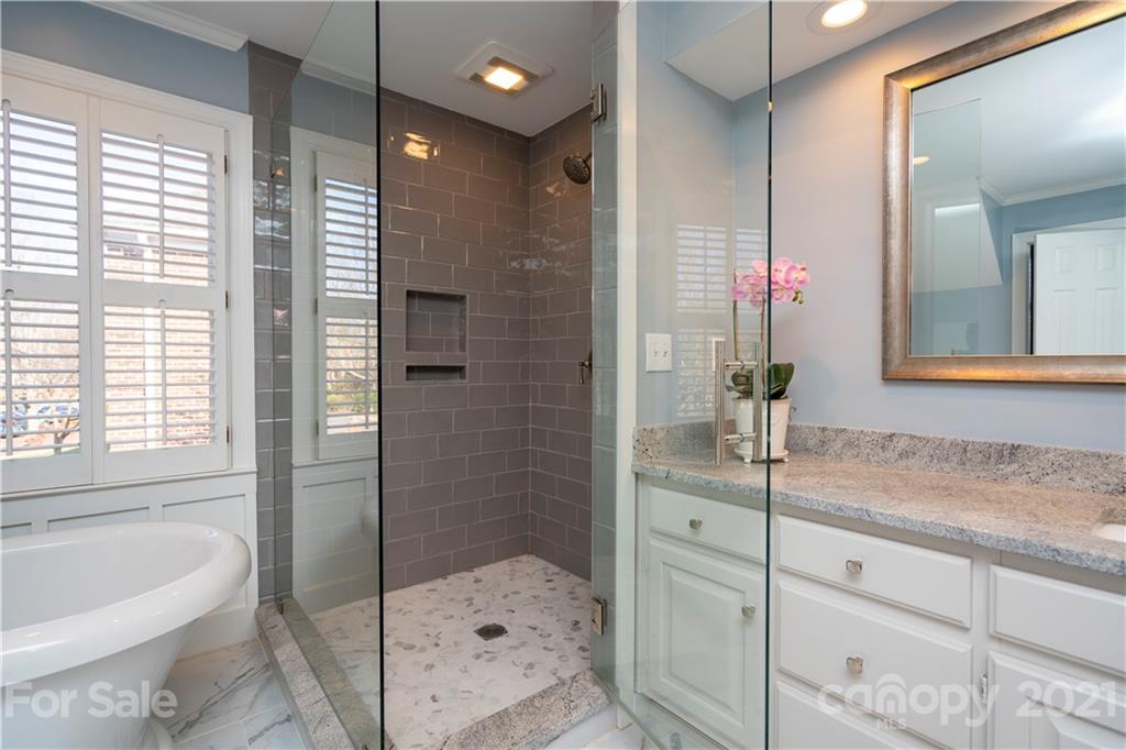 4537 Binfords Ridge Road Charlotte, NC 28226 - Photo 22 of 32 a bathroom with a granite countertop sink a mirror a bathtub and shower