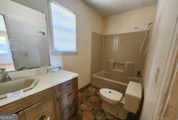 a bathroom with a sink a toilet a mirror and shower