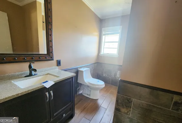 a bathroom with a granite countertop sink a toilet and a mirror