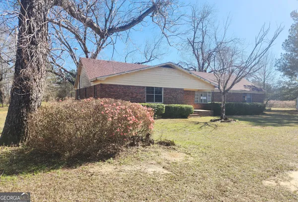 a view of a house with snow on the side of the road
