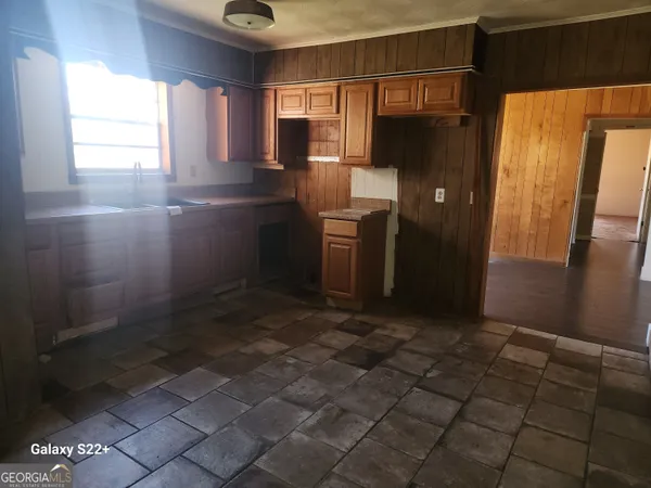 a kitchen with kitchen island granite countertop a refrigerator and a sink