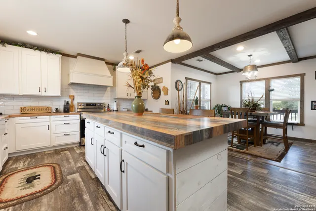 a kitchen with granite countertop a sink a counter space appliances and cabinets