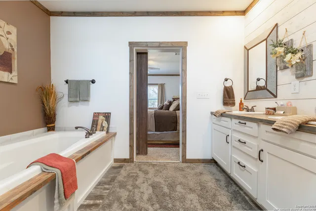 a bathroom with a tub sink and mirror